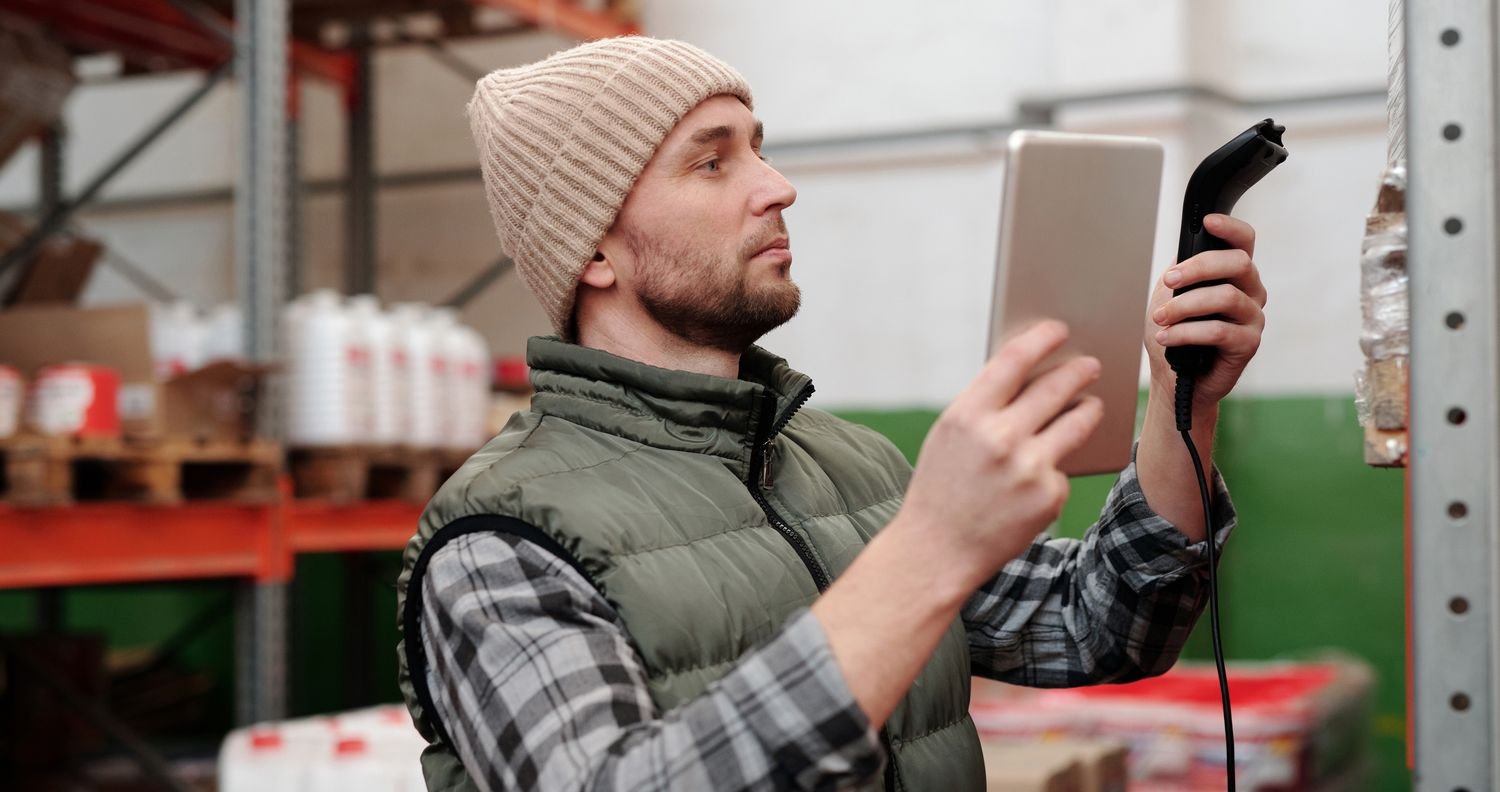 Warehouse worker scanning inventory with a barcode scanner and tablet